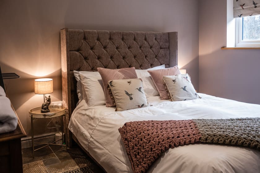 King-size bedroom with upholstered headboard and soft lighting