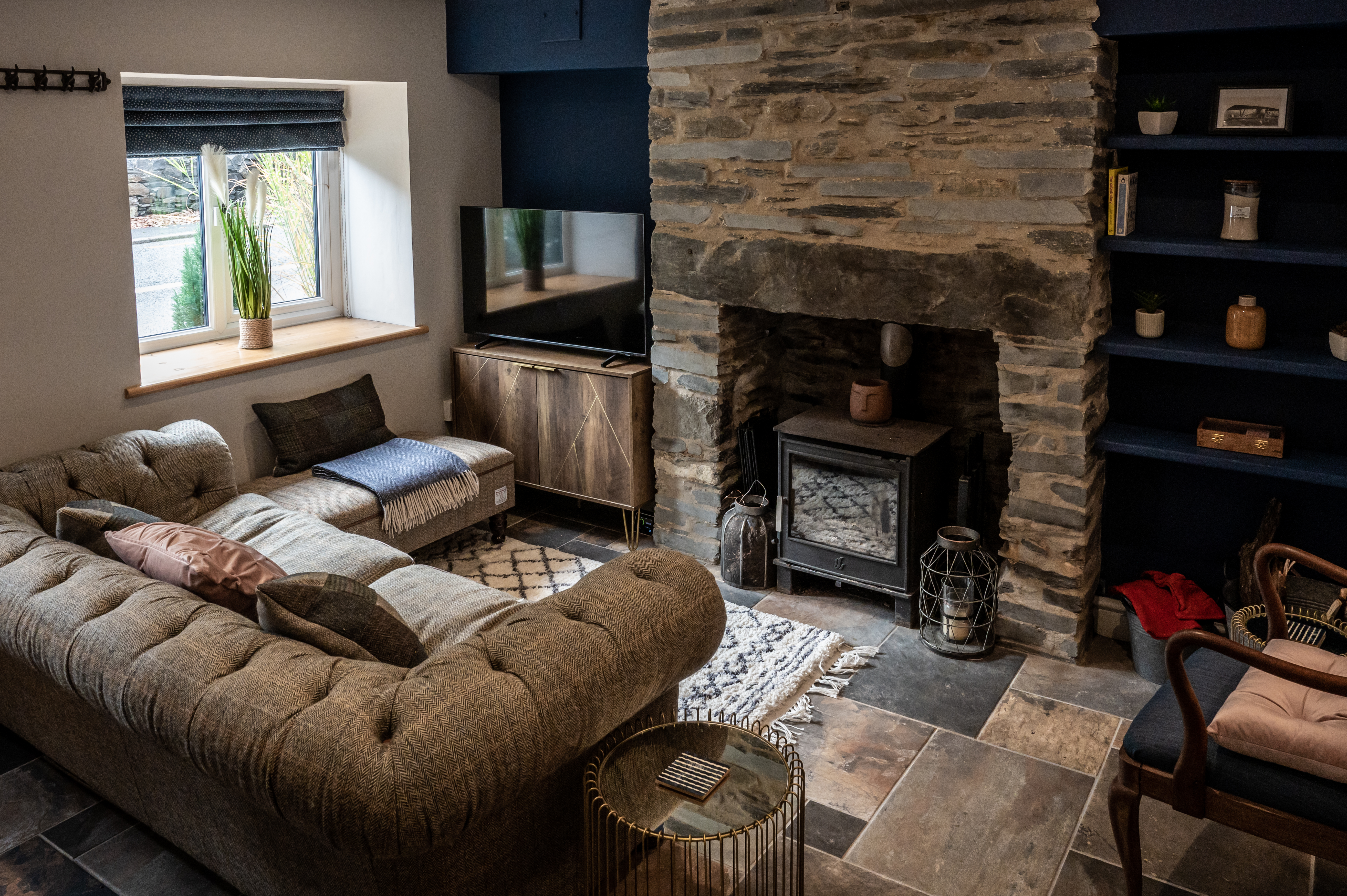 Cosy living room with Harris Tweed sofa and stone fireplace